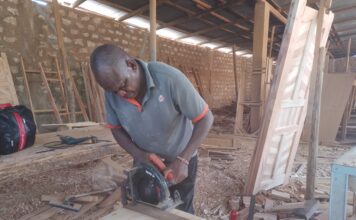 James Mua, disabled, showcases his skills in his workshop. James Mua specializes in boat making making him get money for his family who are disabled too .Photo Courtesy Teryani Mwadzaya