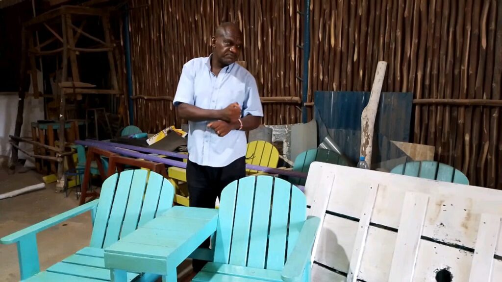 James Mua, disabled, showcases furniture he made at the Moorings floating boat workshop Photo Courtesy Teryani Mwadzaya