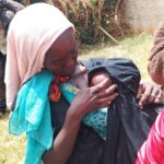 a woman in langas breastfeeding her baby