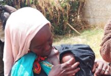 The Cost of Breastfeeding for Working Mothers a woman in langas breastfeeding her baby